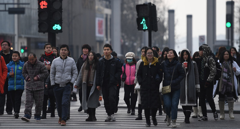 2018年2月1日,杭州街头大量行人匆忙过马路.(中新社)