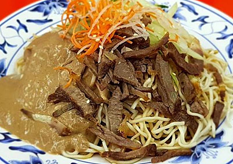 高雄周記涼麵的傳統眷村涼麵基底醬料是用8種中藥和5種蔬菜加入蒜頭、蔥等辛香料熬煮約3小時製成的老滷醬汁,麻醬採用百年手工麻醬加入自行調製的醬料混成,麻醬濃郁且香氣足,涼麵是細白油麵,細軟Q彈,容易吸附醬汁,再擺上黃瓜絲、紅蘿蔔絲和白芝麻,小分35元、大分45元。另還有風味涼麵,分牛豬雞肉3種口味,就是在眷村涼麵中加入老滷汁牛肉或豬、雞肉,小分50元、大分60元。圖為牛肉涼麵(大60元)。(王錦河攝)