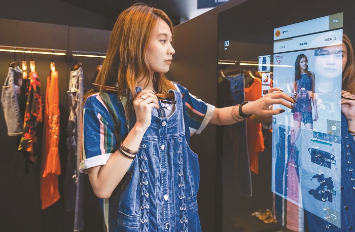 Fashion AI概念店利用AI進行時尚搭配推薦,圖為模特兒展示選購衣服流程。(中新社資料照片)