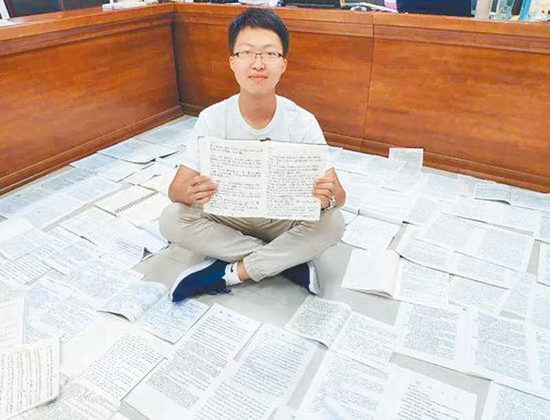 揚州大學學生劉天逸和手抄10萬繁體字作業合影。(取自《中國青年報》微信公眾號)