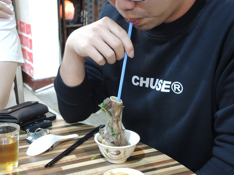 羊大骨放進羊肉爐燉煮一番,用吸管吸骨髓別有樂趣。(邱立雅攝)