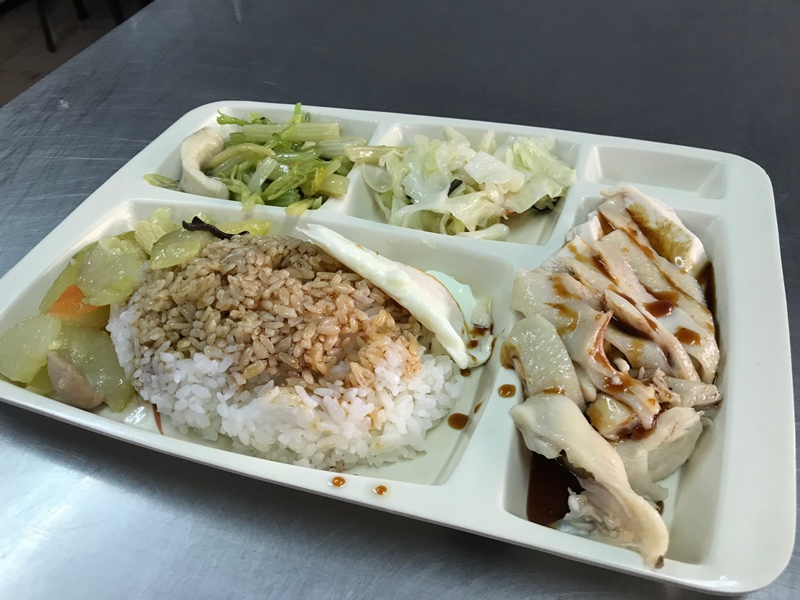 店內招牌的雞肉飯便當,主打現切整盤的雞肉,搭配一大碗淋上特調醬油的白飯。