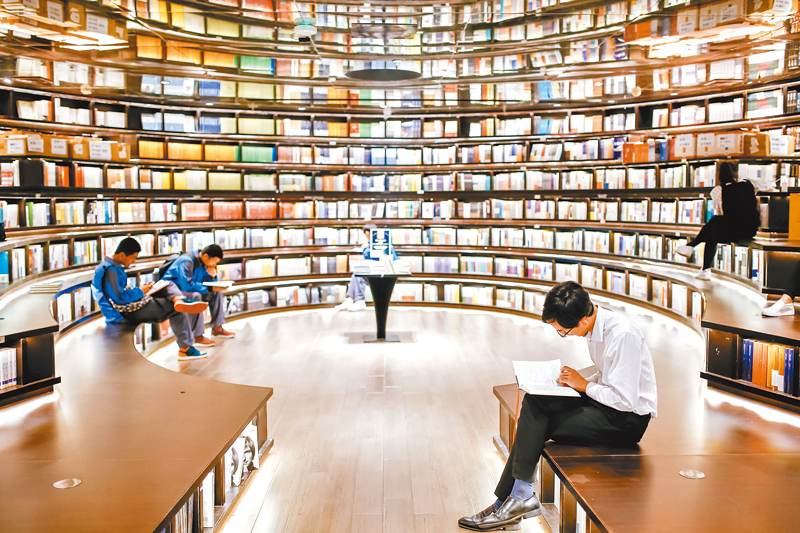 大陸一些特色經營的實體書店,展現了一座城市的公共空間和文化新地標。圖為讀者在書店內閱讀。(新華社資料照片)