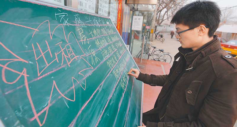 北京一家房仲在展示板上書寫新增的出租房。(新華社資料照片)
