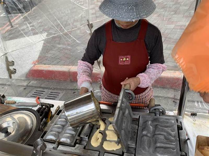 設備簡單的手推車,賣的卻是許多板橋人熟知的雞蛋糕,攤前經常大排長龍。(王揚傑攝)